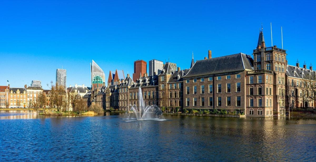 a large building with a fountain in the middle of a lake