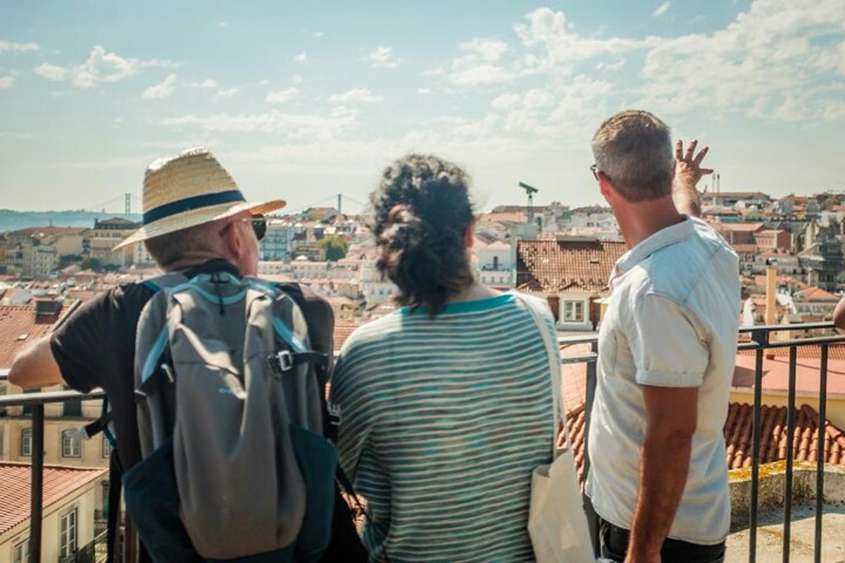 Tres personas paradas en un balcón mirando una ciudad.
