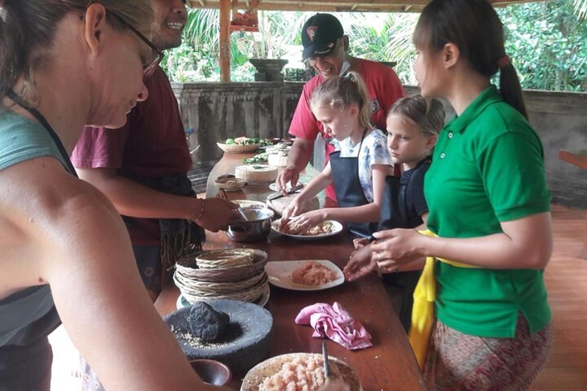 a group of people standing around a table with food