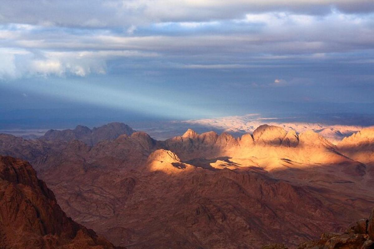 a view of a mountain range with the sun setting