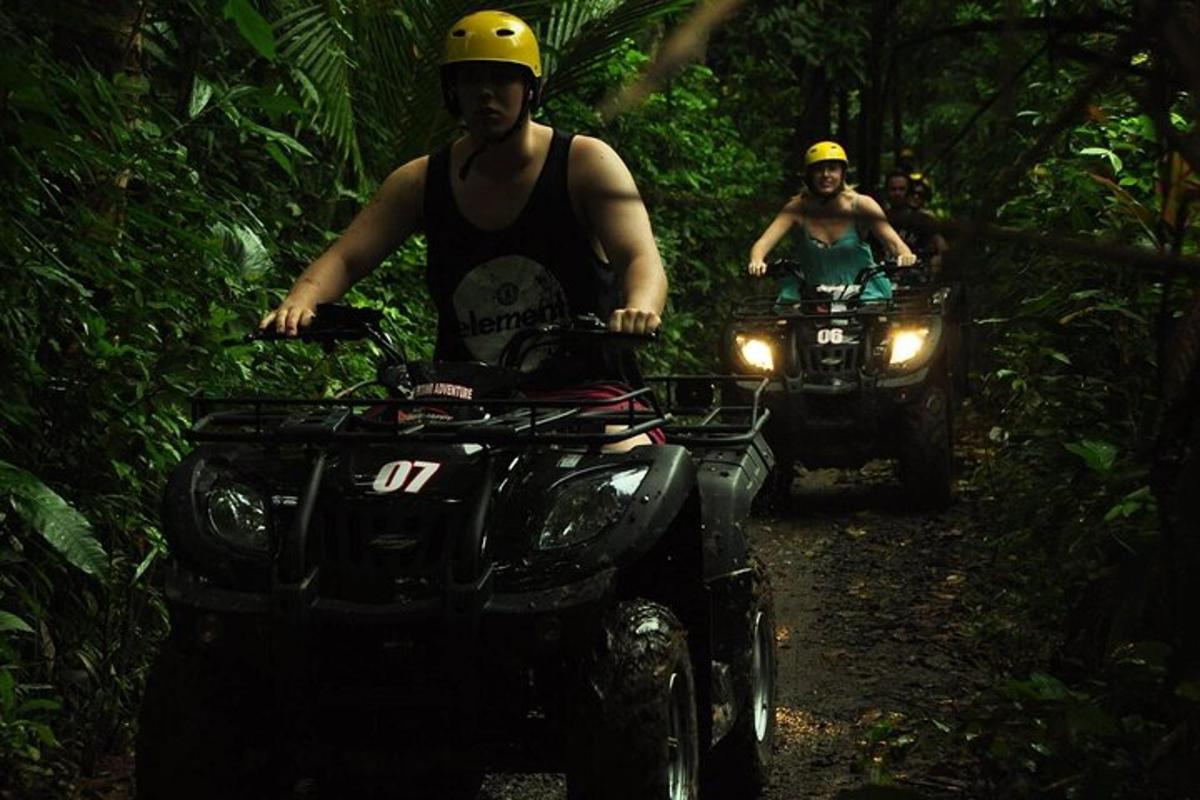 dalawang tao na nakasakay sa mga atv sa isang trail sa kakahuyan