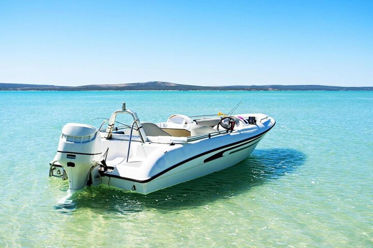 Un barco blanco que se encuentra en el agua sobre un cuerpo de agua.