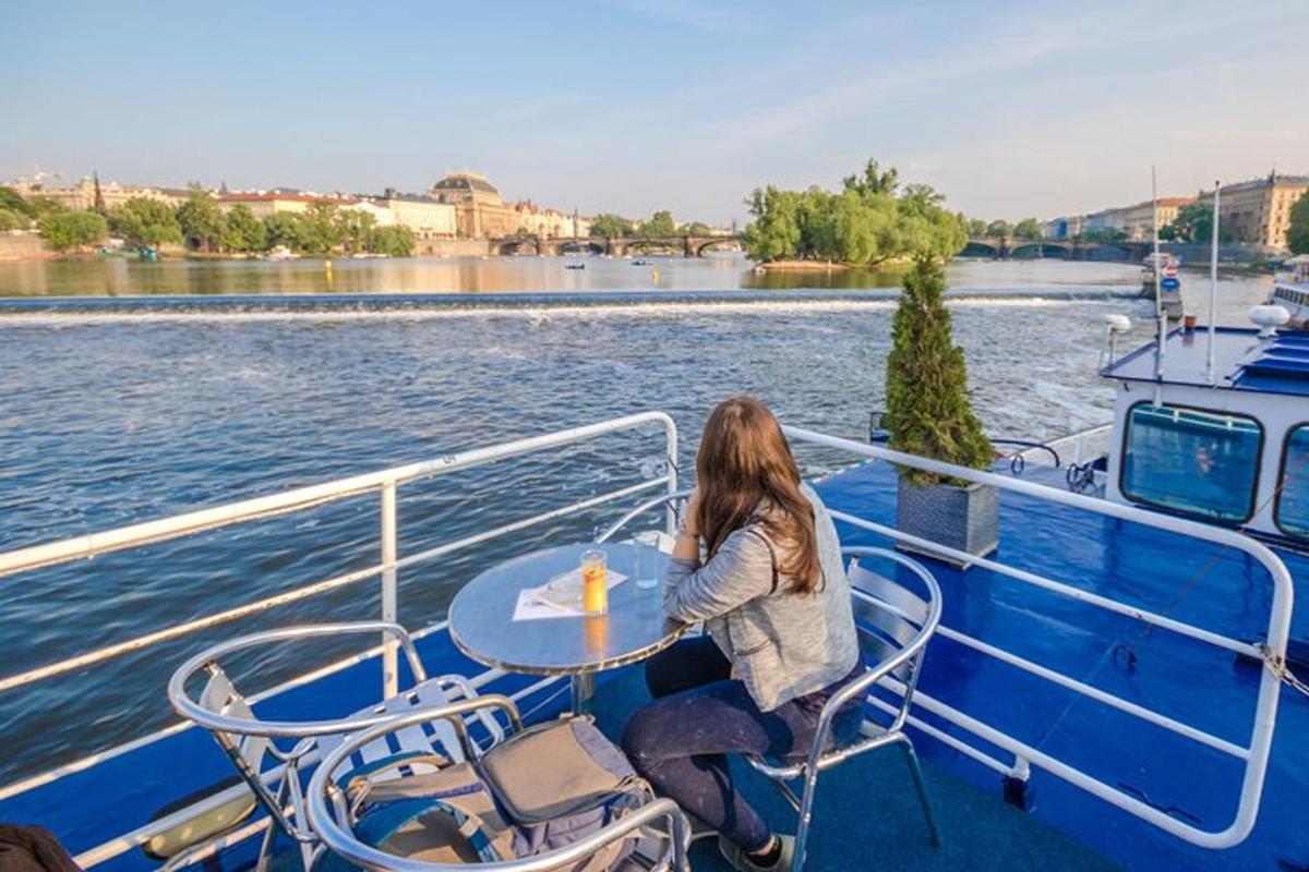 uma mulher sentada à mesa no convés de um barco