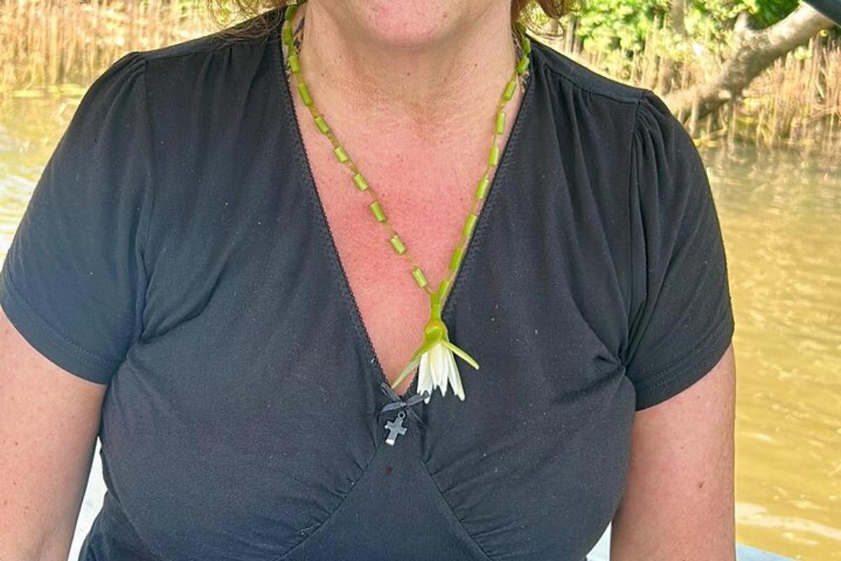 una donna che indossa una collana con un fiore