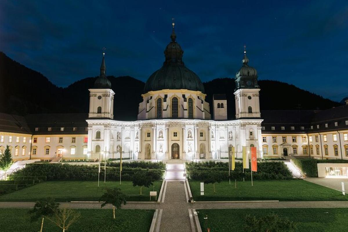 un grande edificio di notte con un giardino di fronte