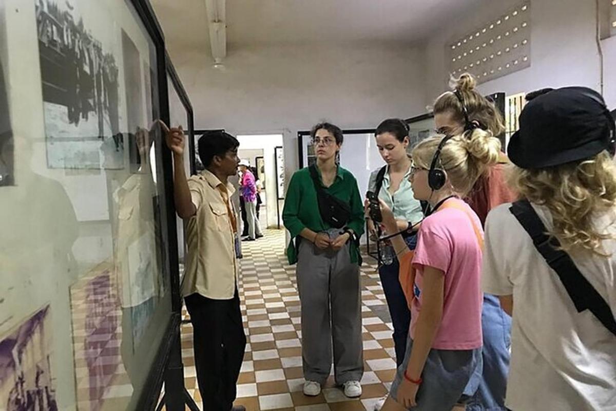 um grupo de pessoas em pé em uma sala olhando para uma pintura