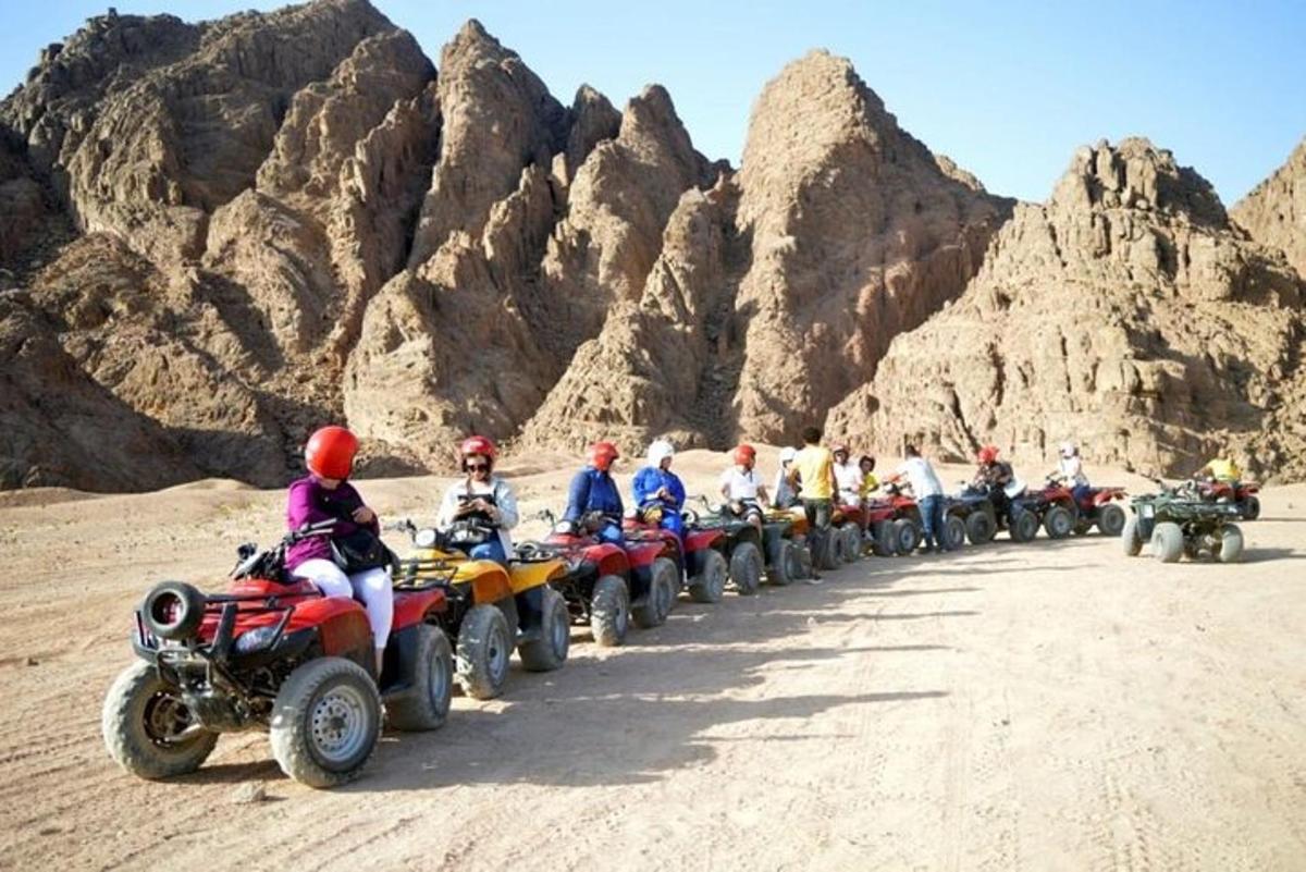 um grupo de pessoas andando de quadriciclo no deserto