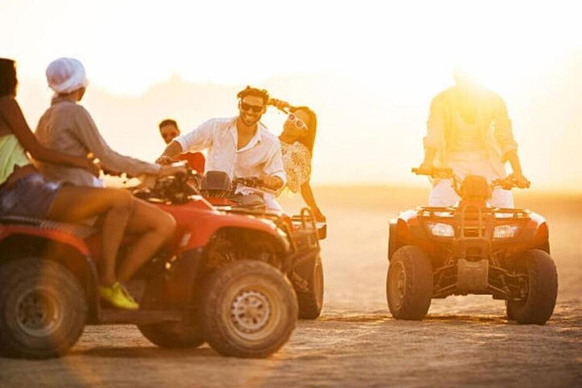 un gruppo di persone che guidano quad nel deserto