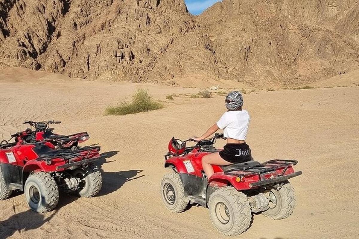 a person riding on four wheelers in the desert
