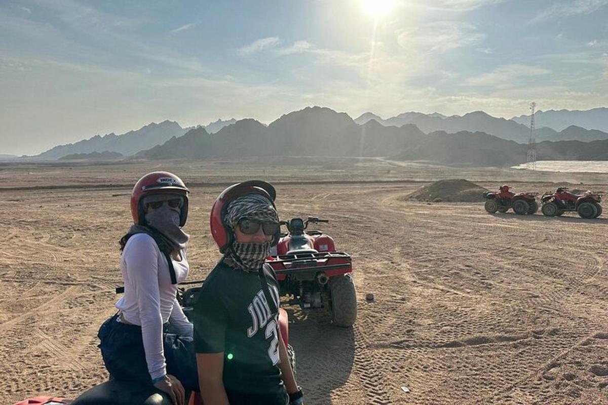 two people on a dirt bike in the desert