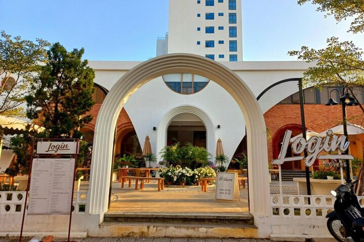 Un arco frente a un edificio con mesas y sillas.