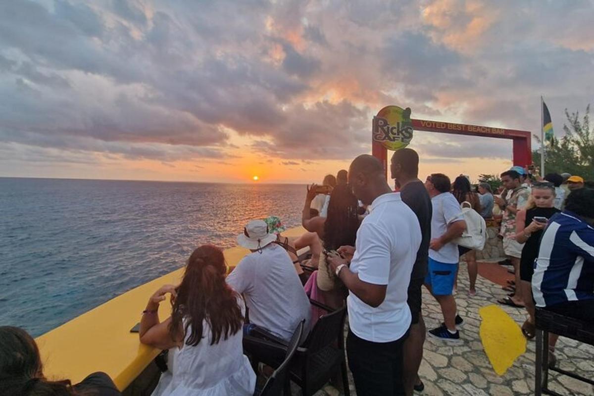 un gruppo di persone in piedi a guardare il tramonto