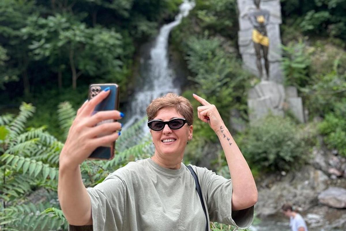 seorang wanita mengambil gambar air terjun