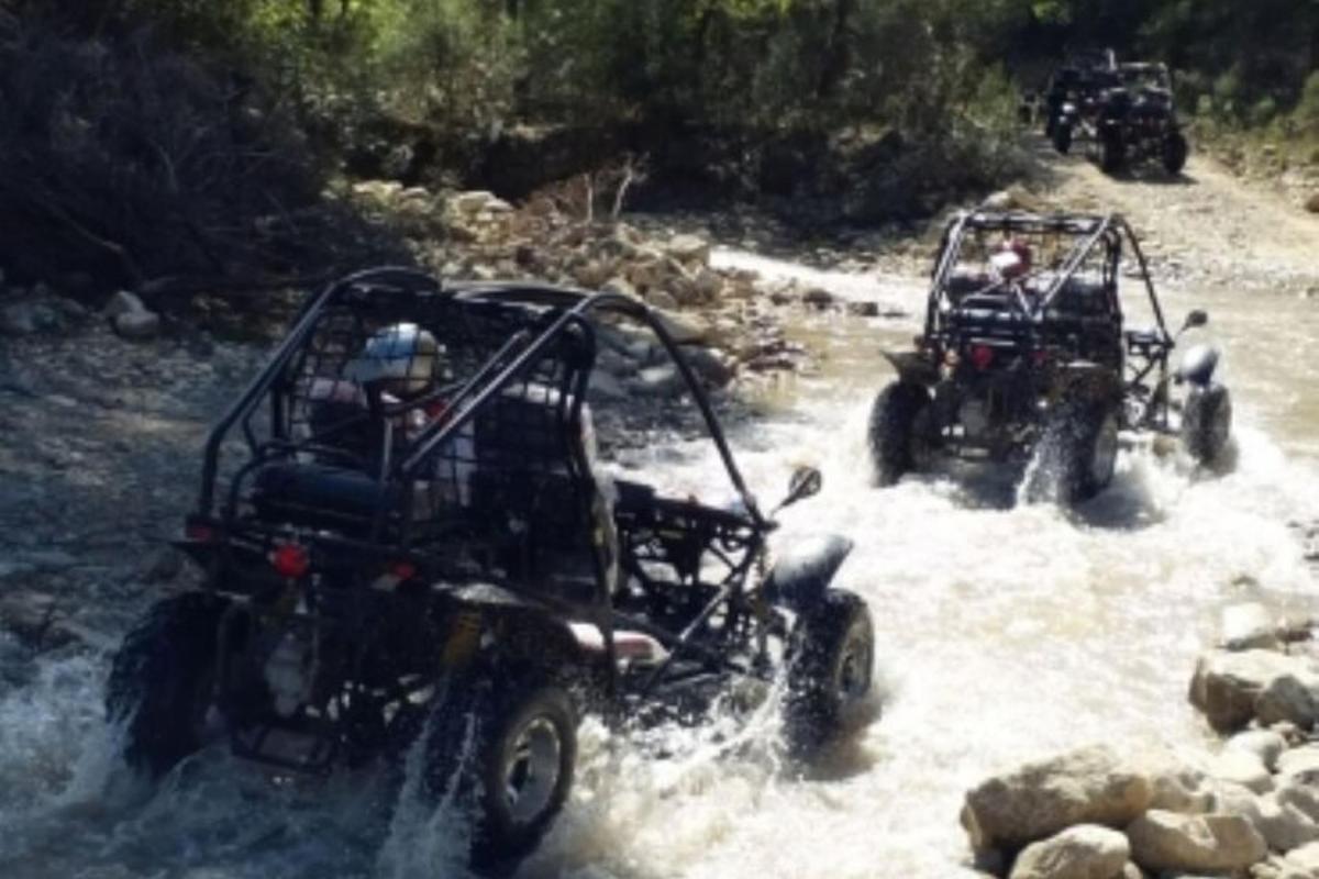 twee ATV's rijden door het water in een rivier