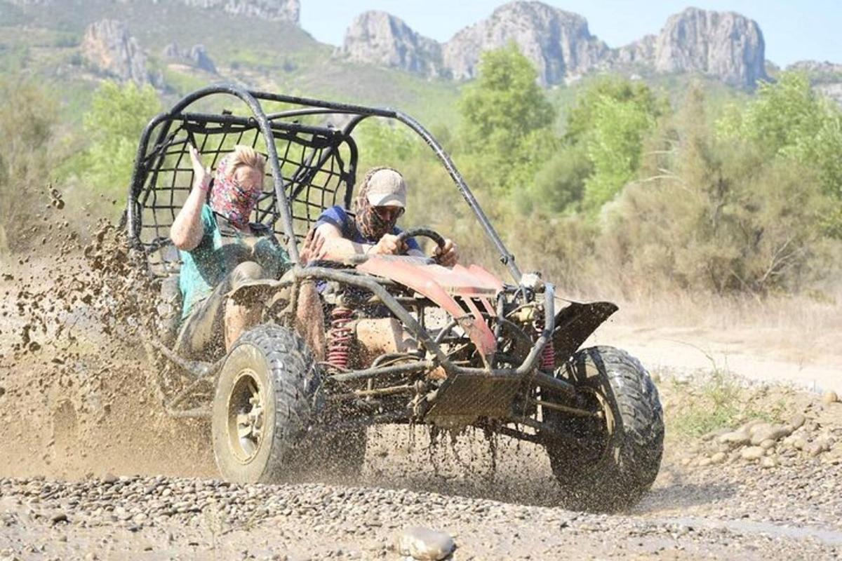 due persone in sella a un quad su una strada sterrata