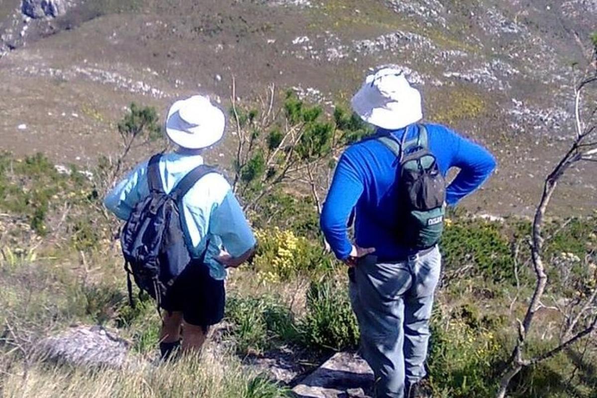 dua orang dengan beg galas berdiri di atas gunung