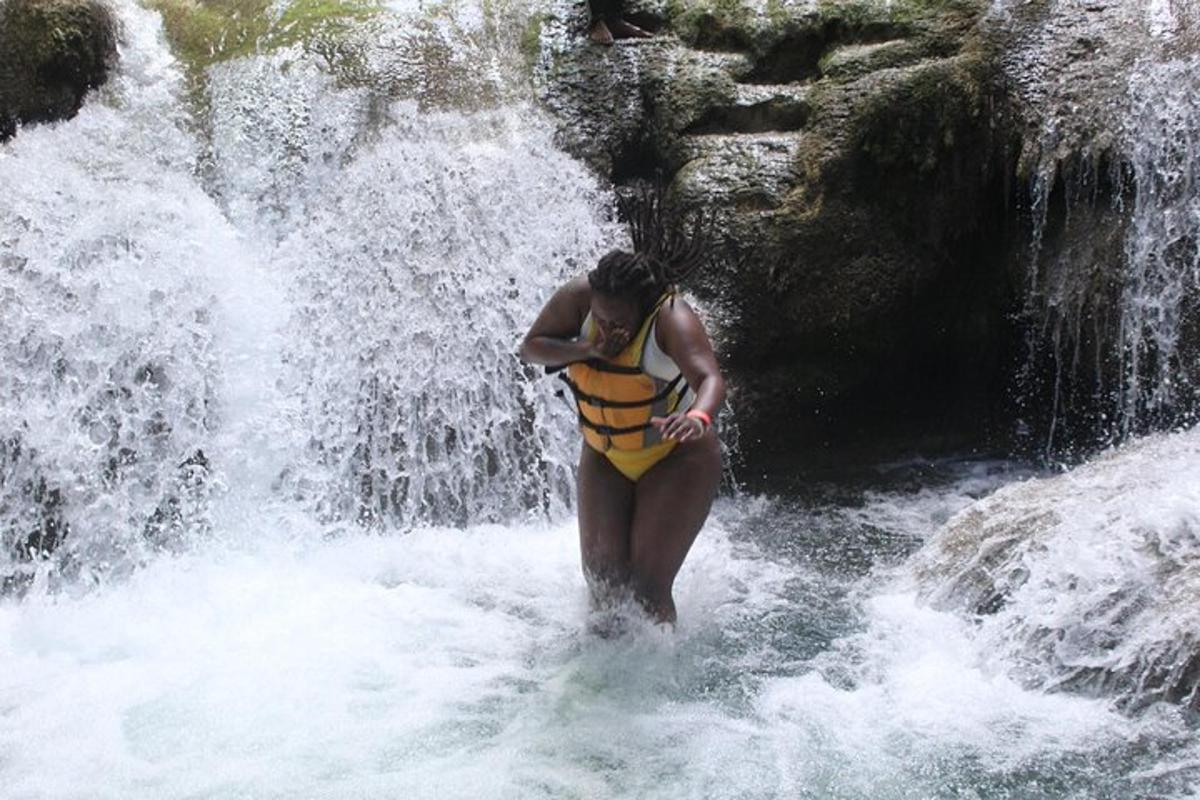 una donna in piedi nell'acqua vicino a una cascata