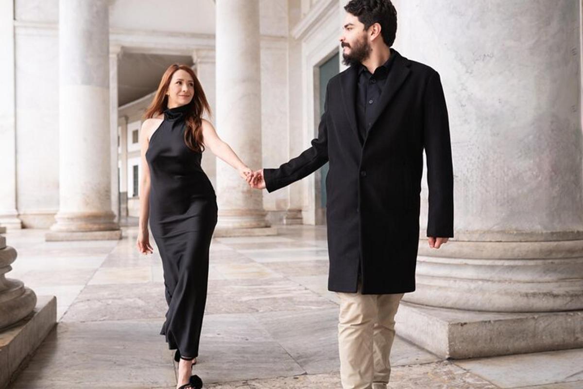 un uomo e una donna che si tengono per mano mentre camminano davanti a un edificio