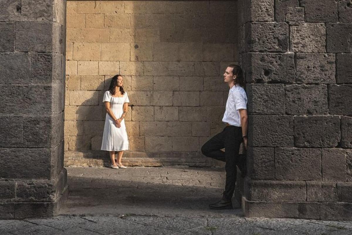 un uomo e una donna in piedi accanto a un muro