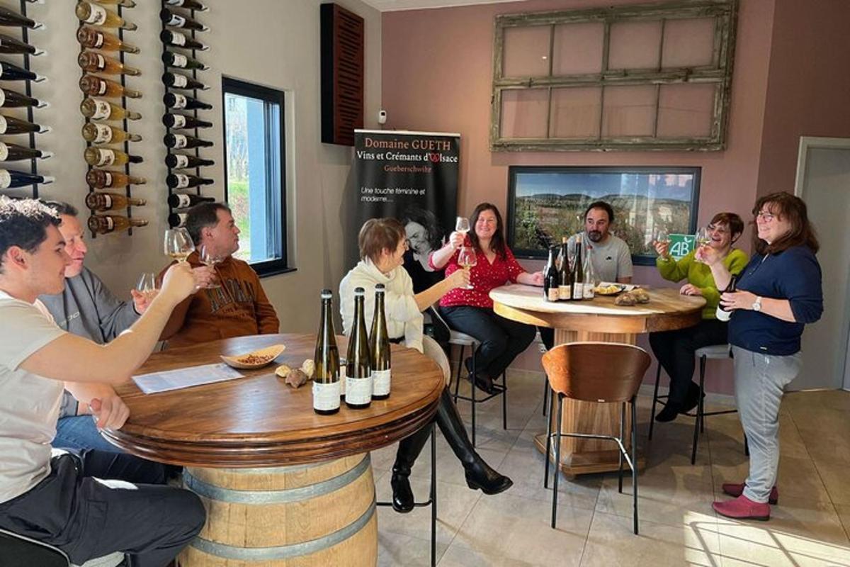 a group of people sitting at tables in a wine cellar