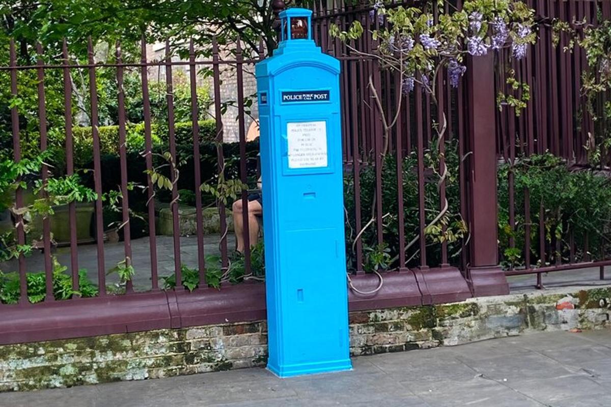 una bottiglia blu appoggiata davanti a una recinzione