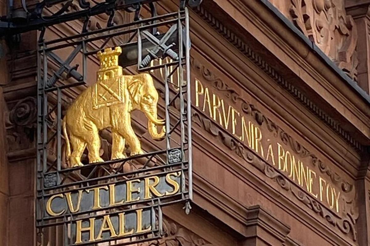 un cartello con un elefante dorato sul lato di un edificio