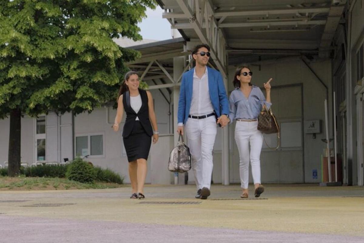 un gruppo di tre persone che camminano lungo un marciapiede
