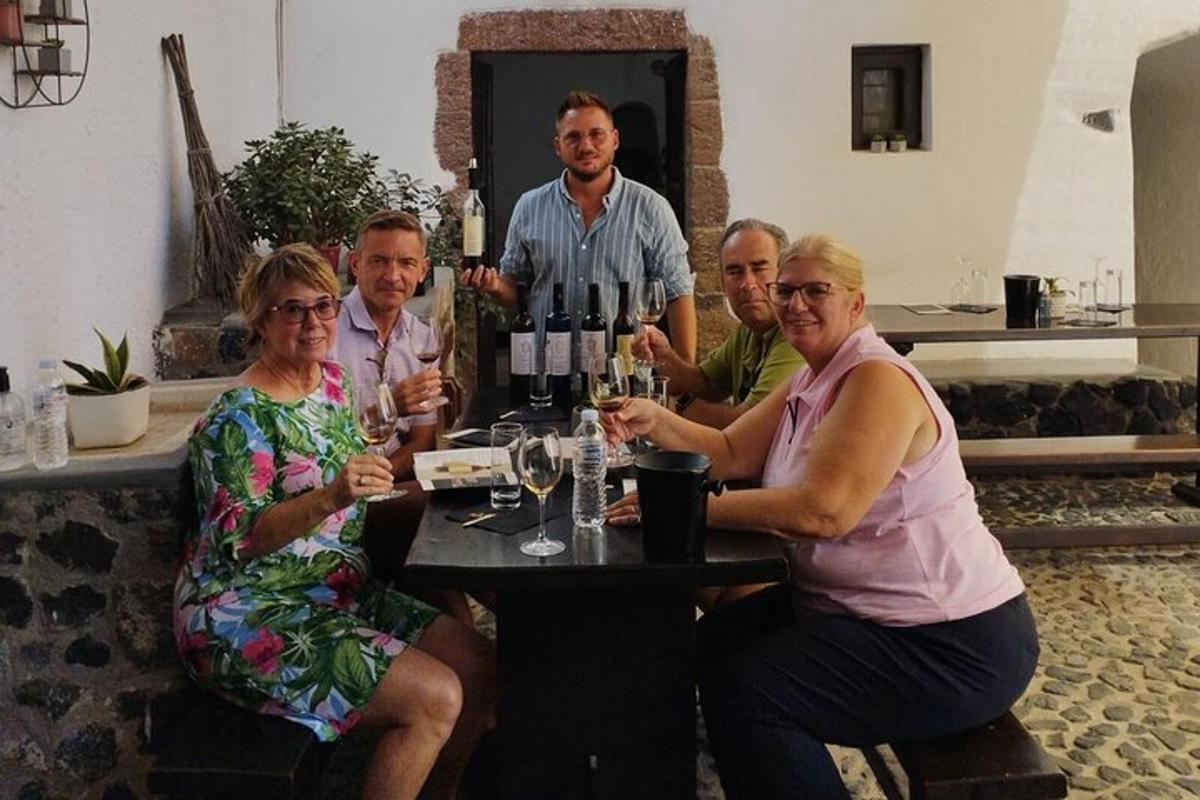 een groep mensen die aan een tafel zitten met wijnglazen