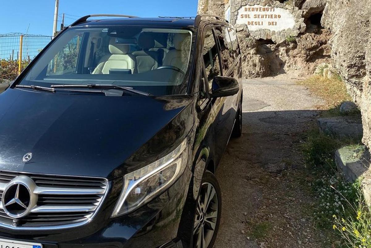un coche negro estacionado en un camino de tierra