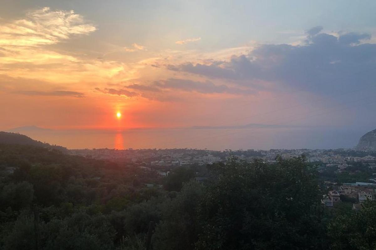 Una puesta de sol con el sol poniéndose sobre una ciudad