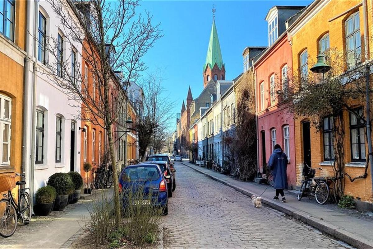 egy nő kutyát sétáltat egy macskaköves utcán
