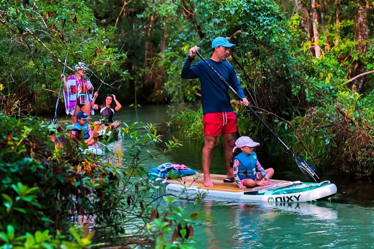 muž a dítě na paddleboardu ve vodě