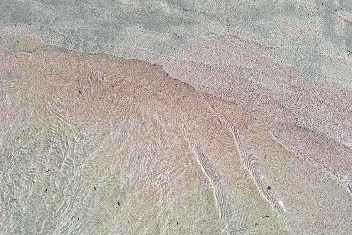 an aerial view of the sand and water on a beach