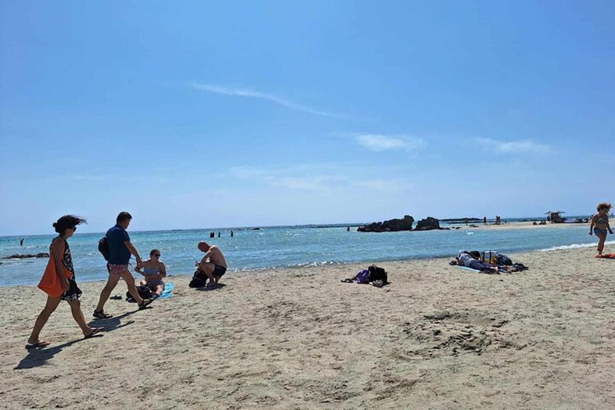 a group of people walking on the beach