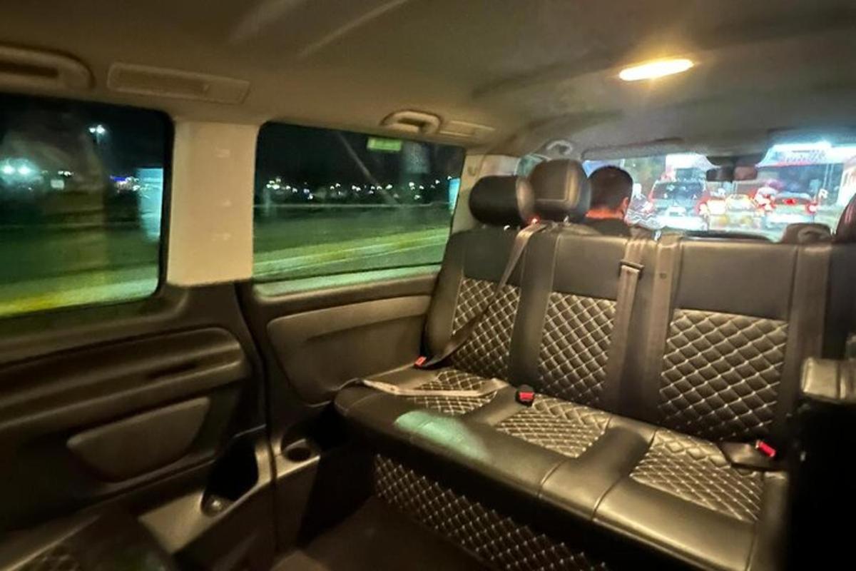 seorang lelaki duduk di kerusi belakang kereta