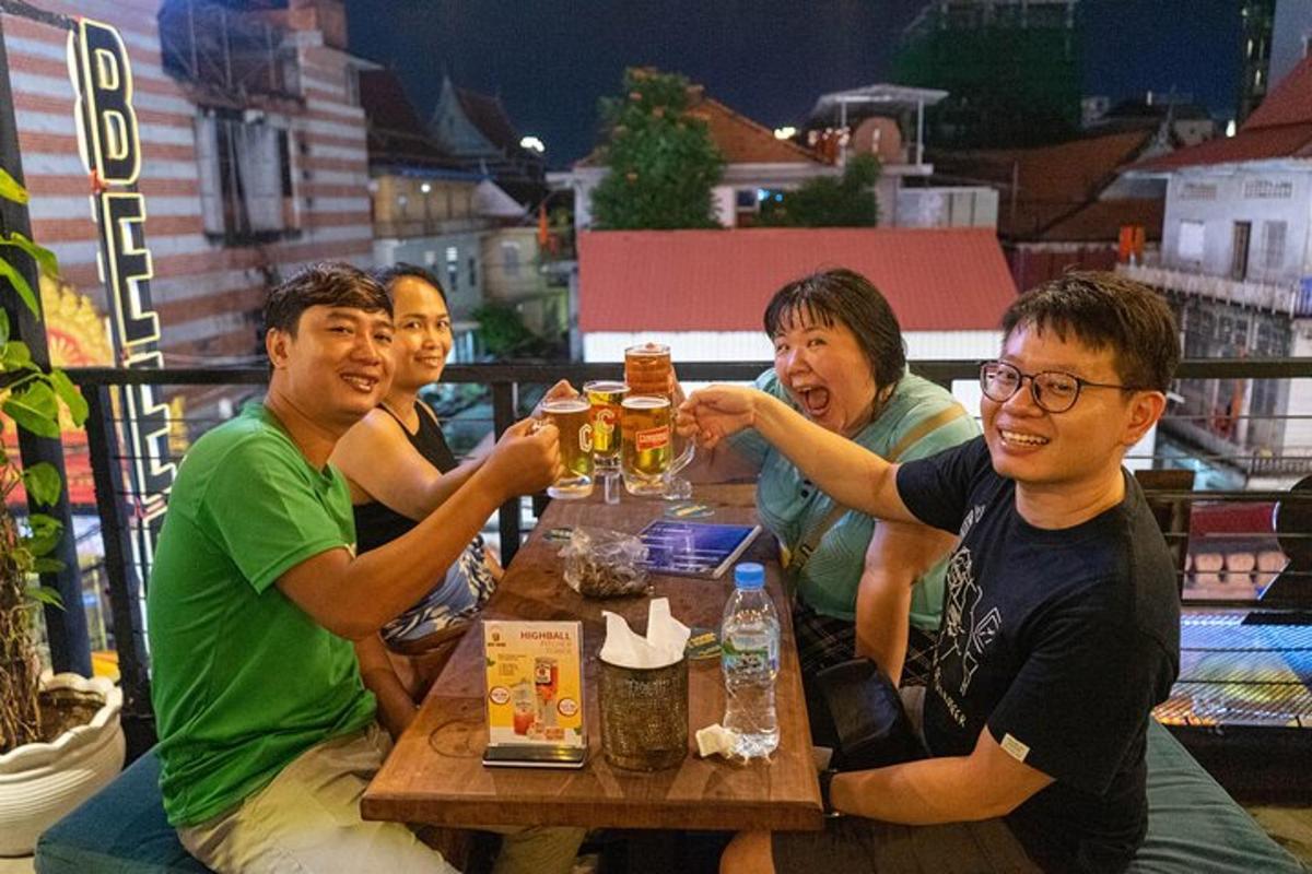 sekumpulan orang duduk di meja sambil minum bir