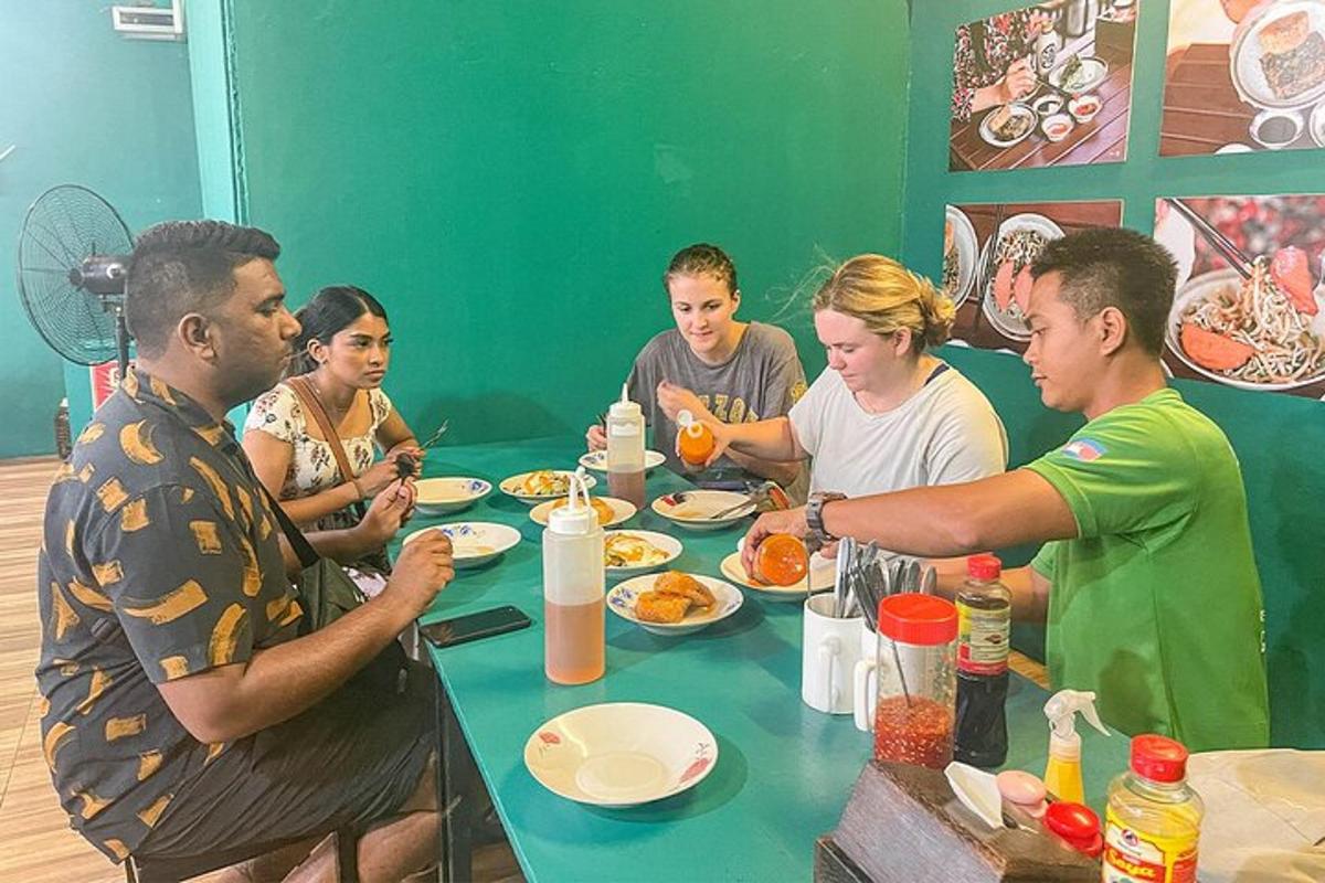 sekumpulan orang duduk mengelilingi meja makan makanan