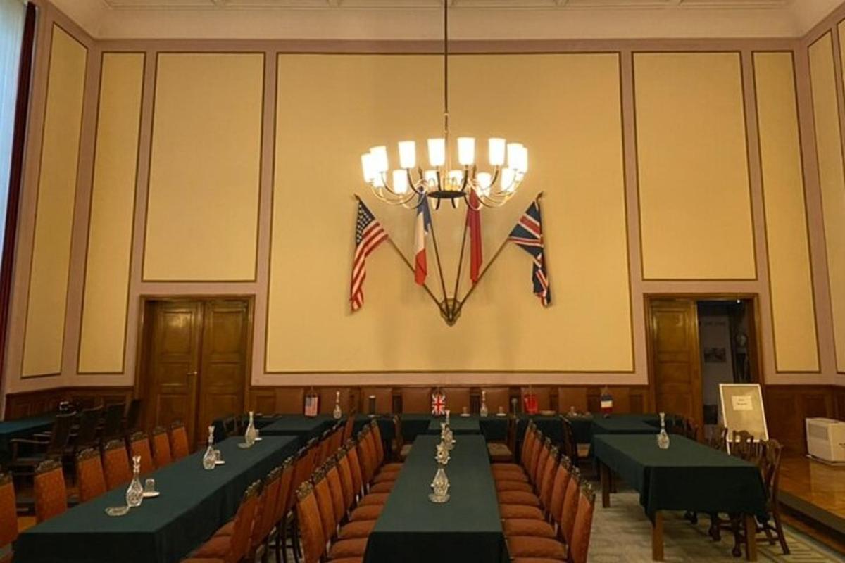 konferenční místnost se stoly a vlajkami na zdi