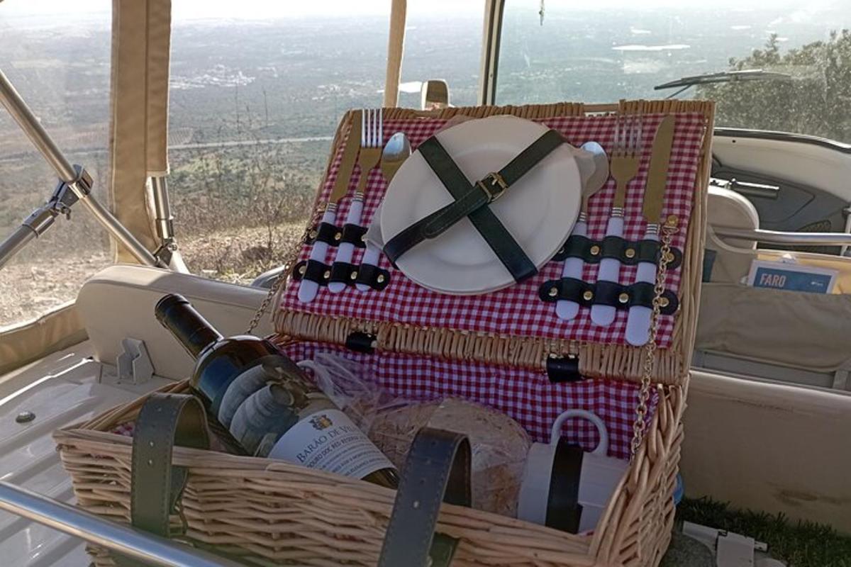 košara, polna steklenic vina, in krožnik