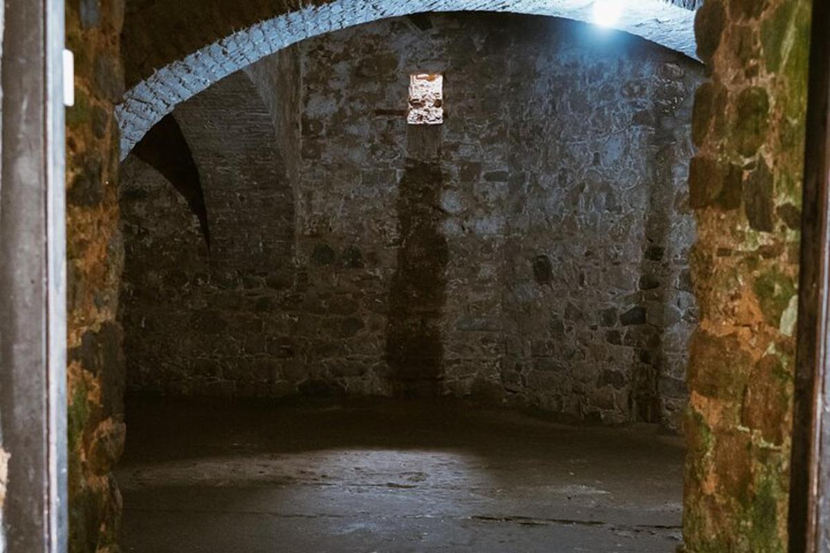 an old brick tunnel with a light at the end of it
