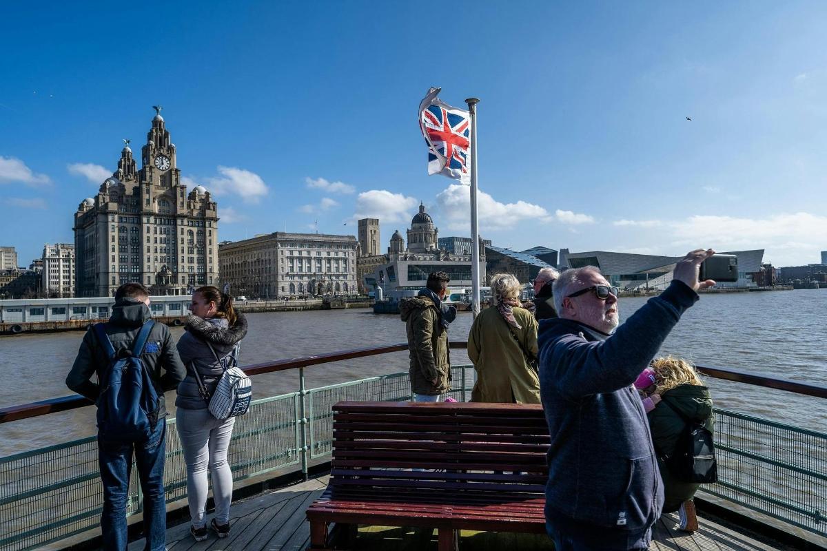 a group of people standing on a bridge near the water