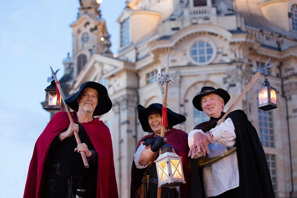 three people dressed in costumes standing in front of a building