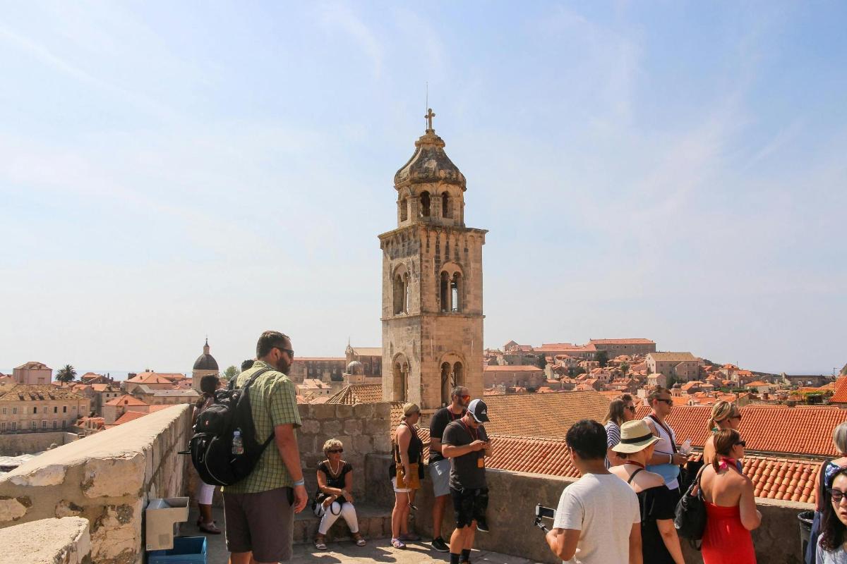 a group of people standing on a wall looking at a tower