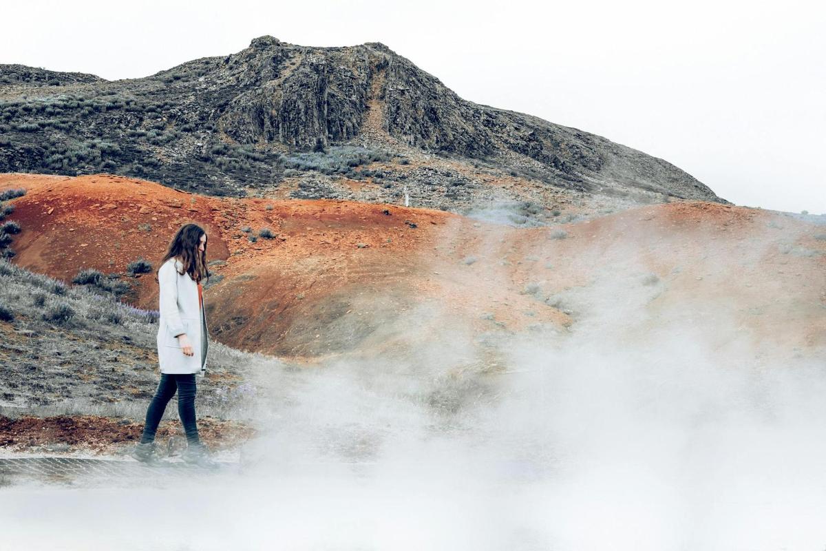 a woman walking in front of a mountain