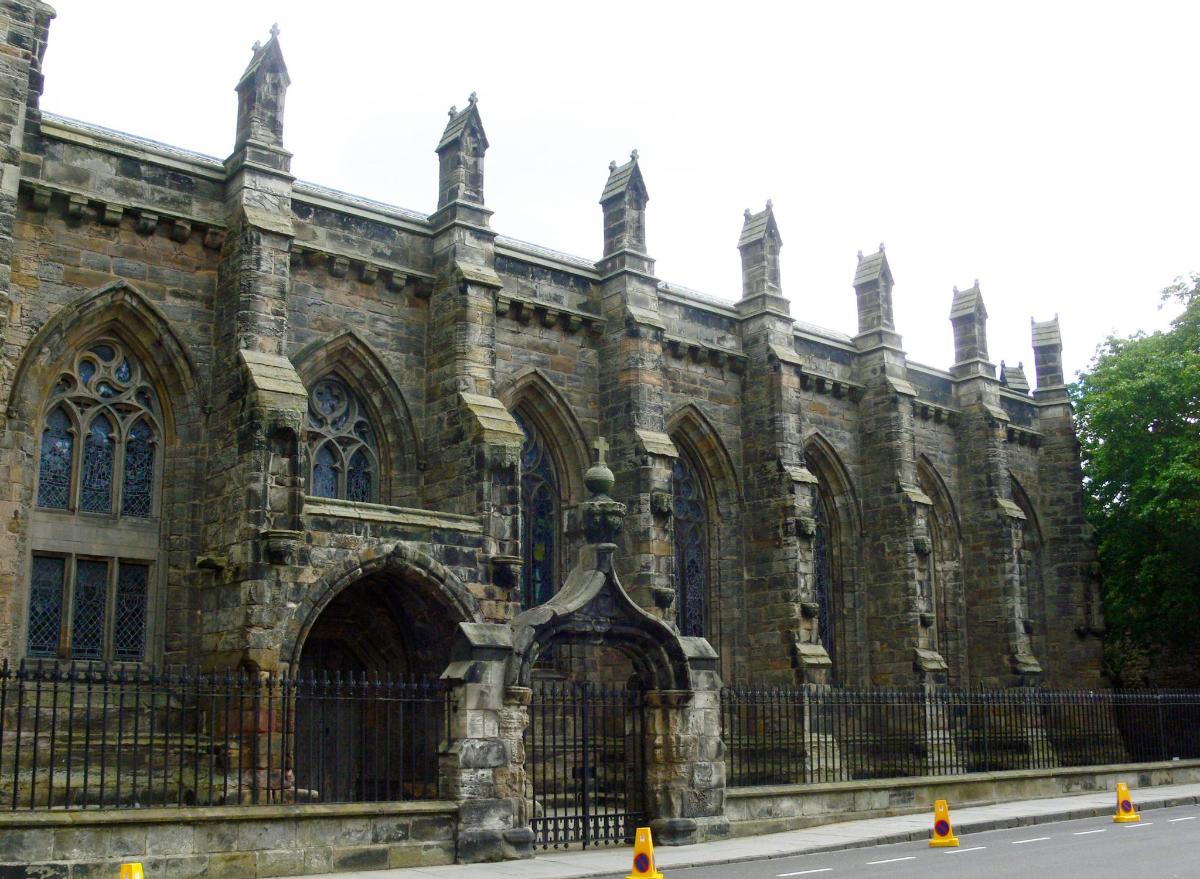 an old stone building with a fence in front of it