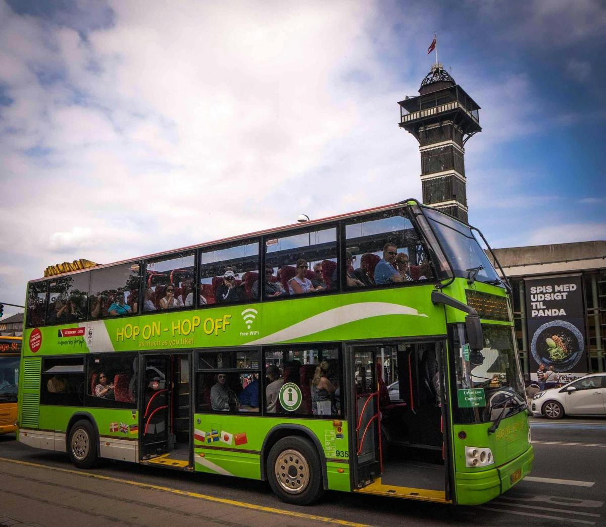 zelený dvoupatrový autobus jedoucí po ulici