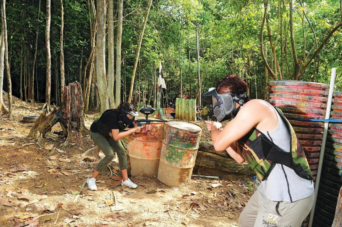 two people standing in a forest with barrels
