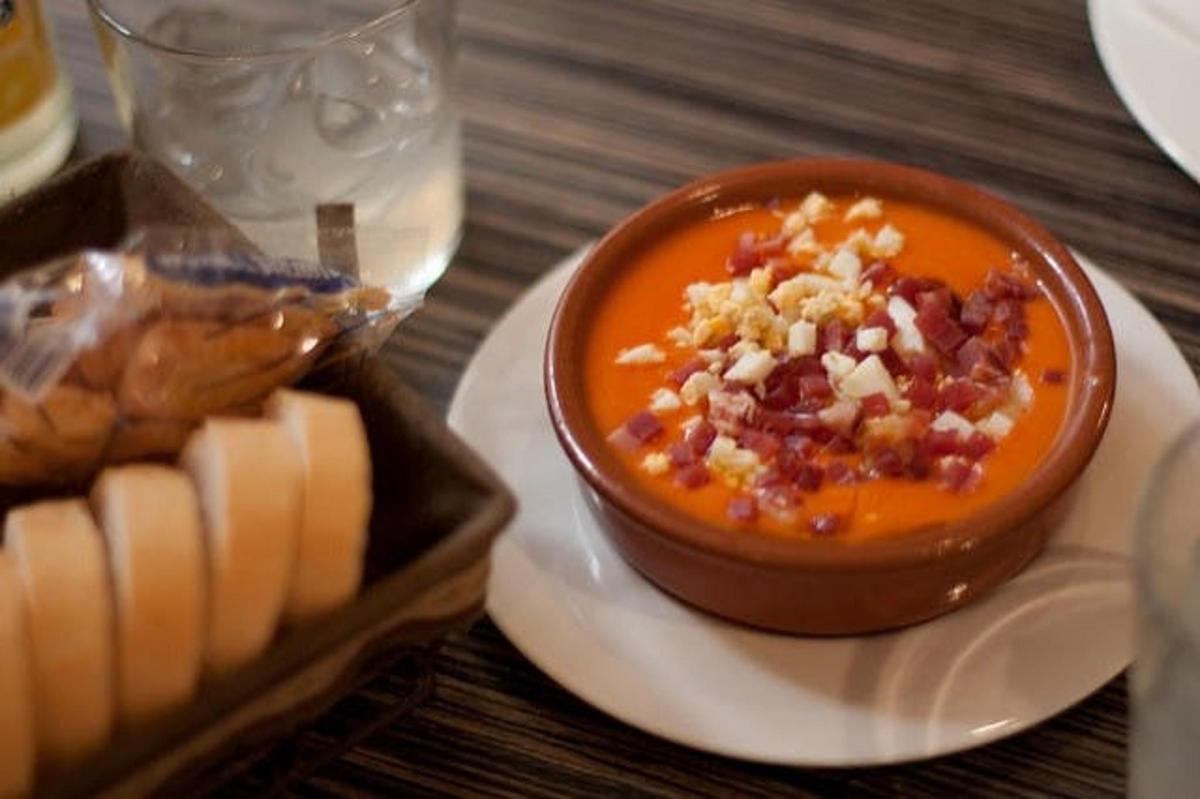 um prato de comida com uma tigela de sopa e pão