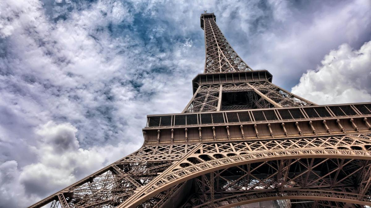 Una vista de la Torre Eiffel bajo un cielo nublado.