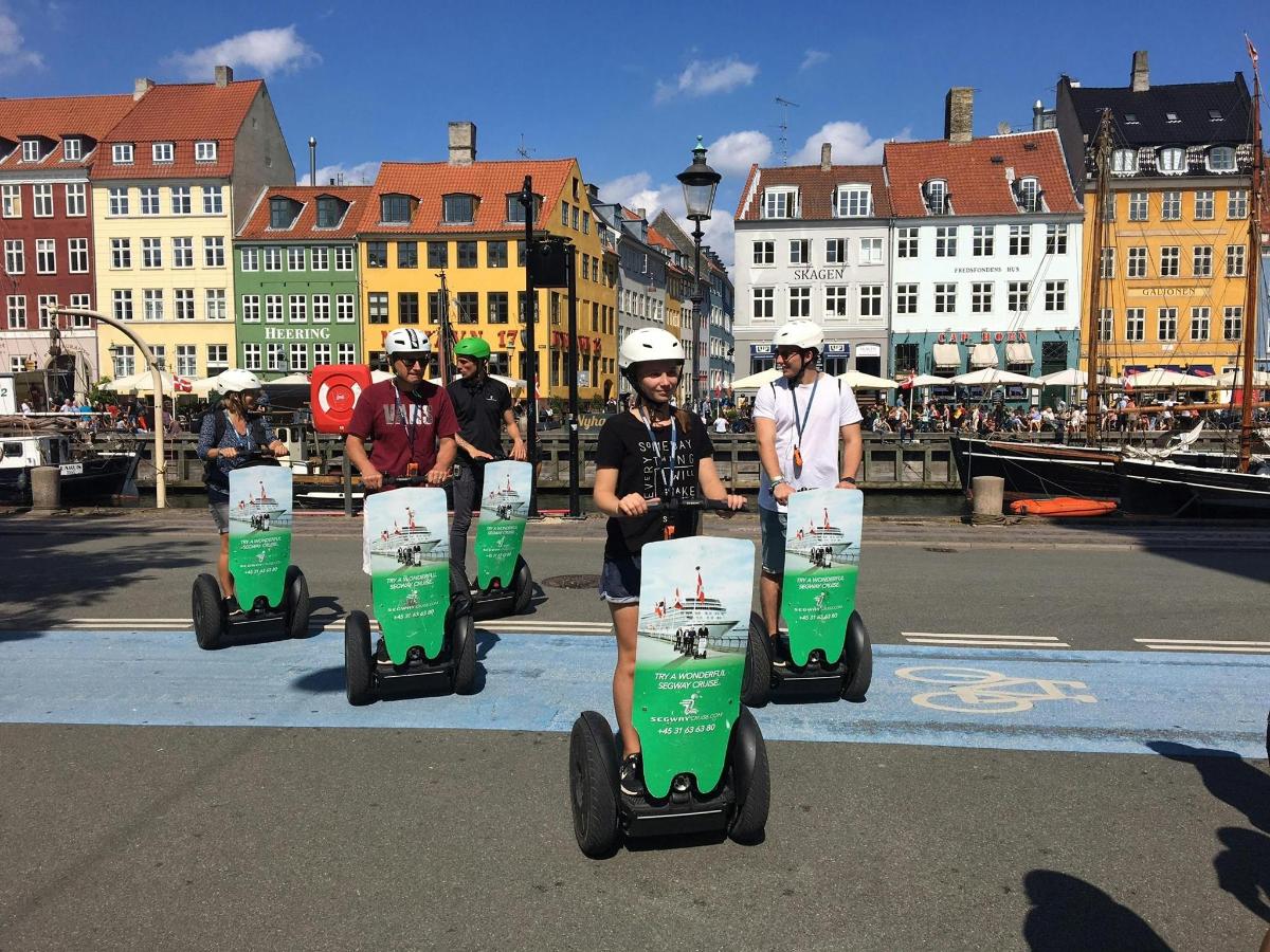 egy csoport ember segwayeken utazik egy városban